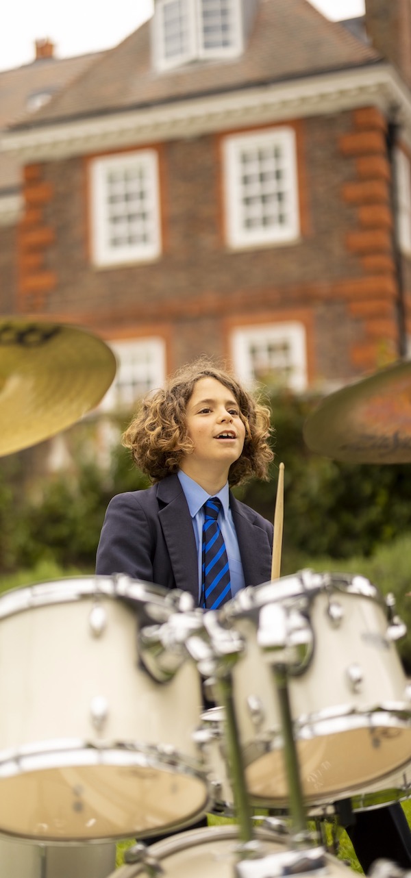 A senior pupil is playing the drums.
