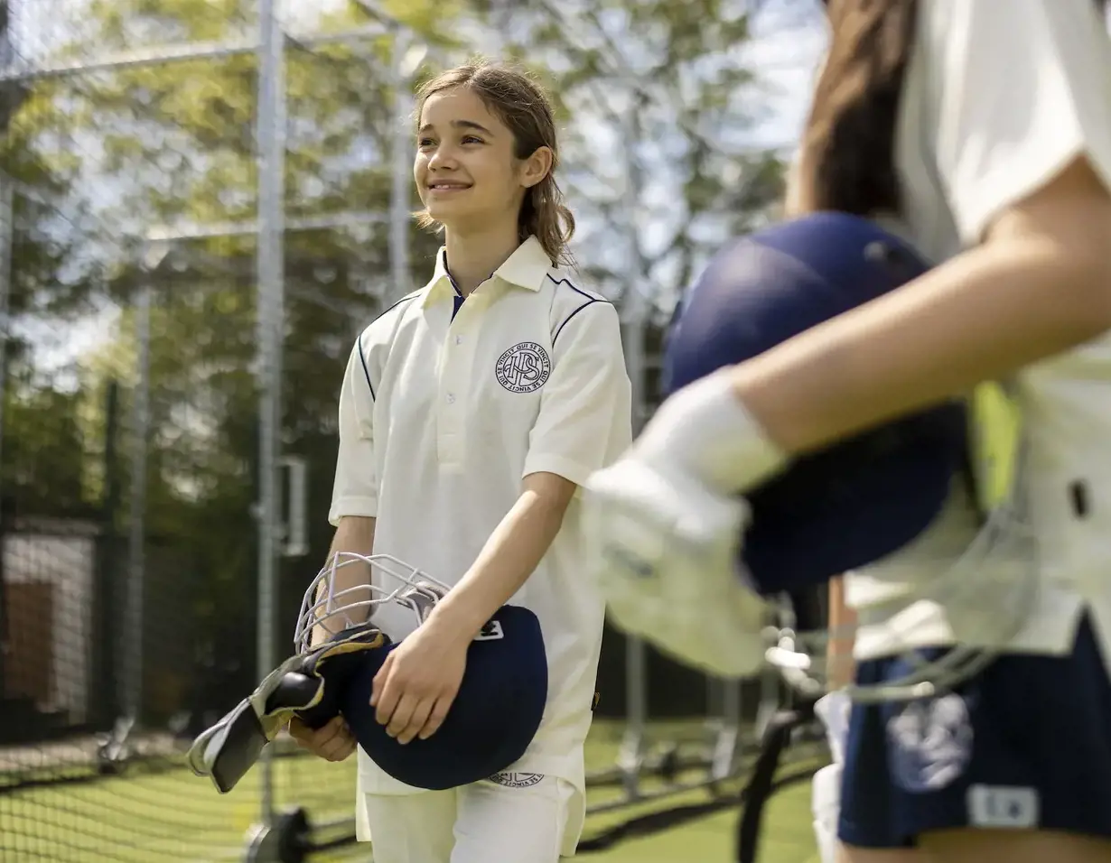 Senior pupil in cricket gear in grounds of Ibstock Place School, near Richmond.