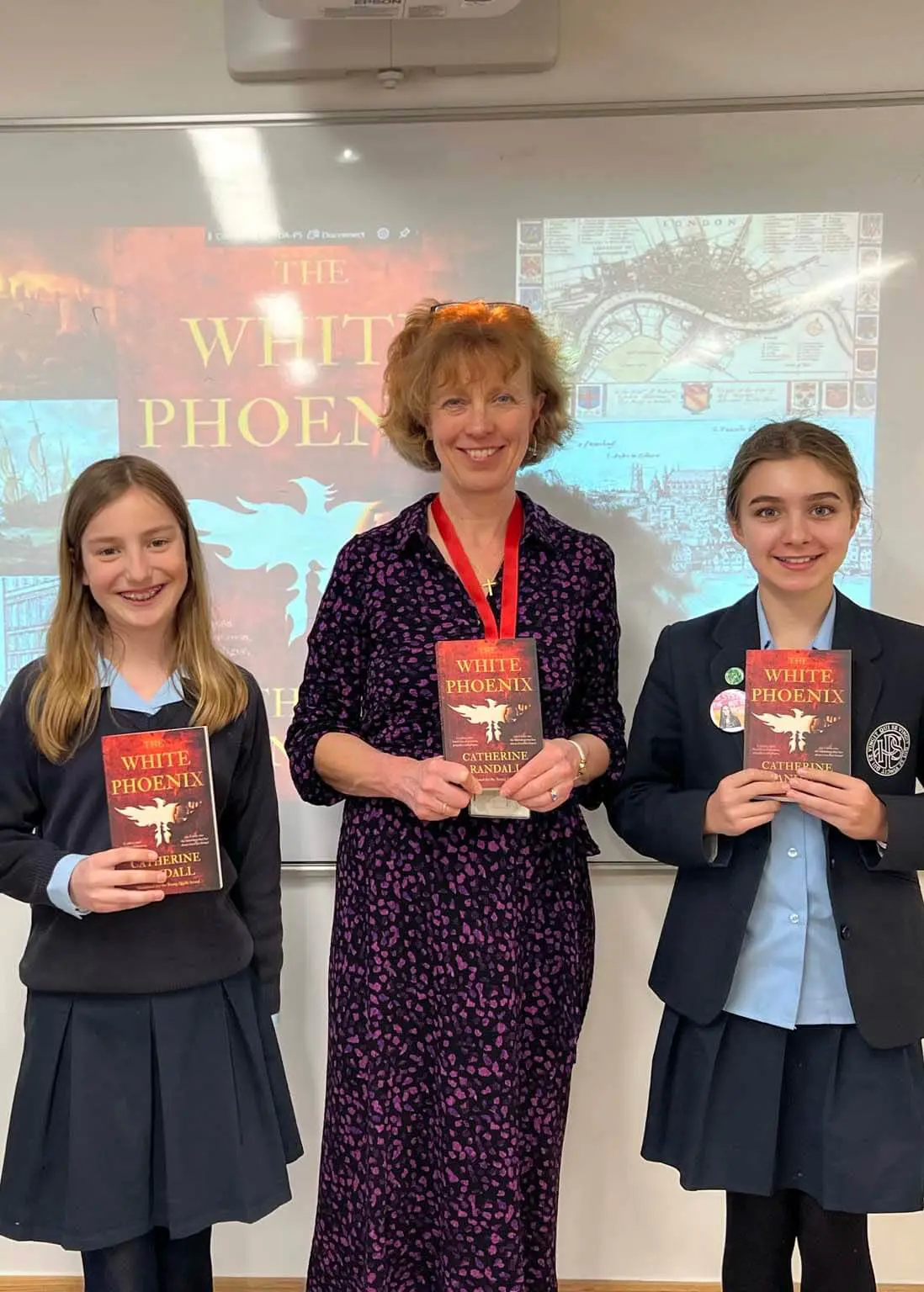 Pupils standing with Catherine Randall with her books in their hands.