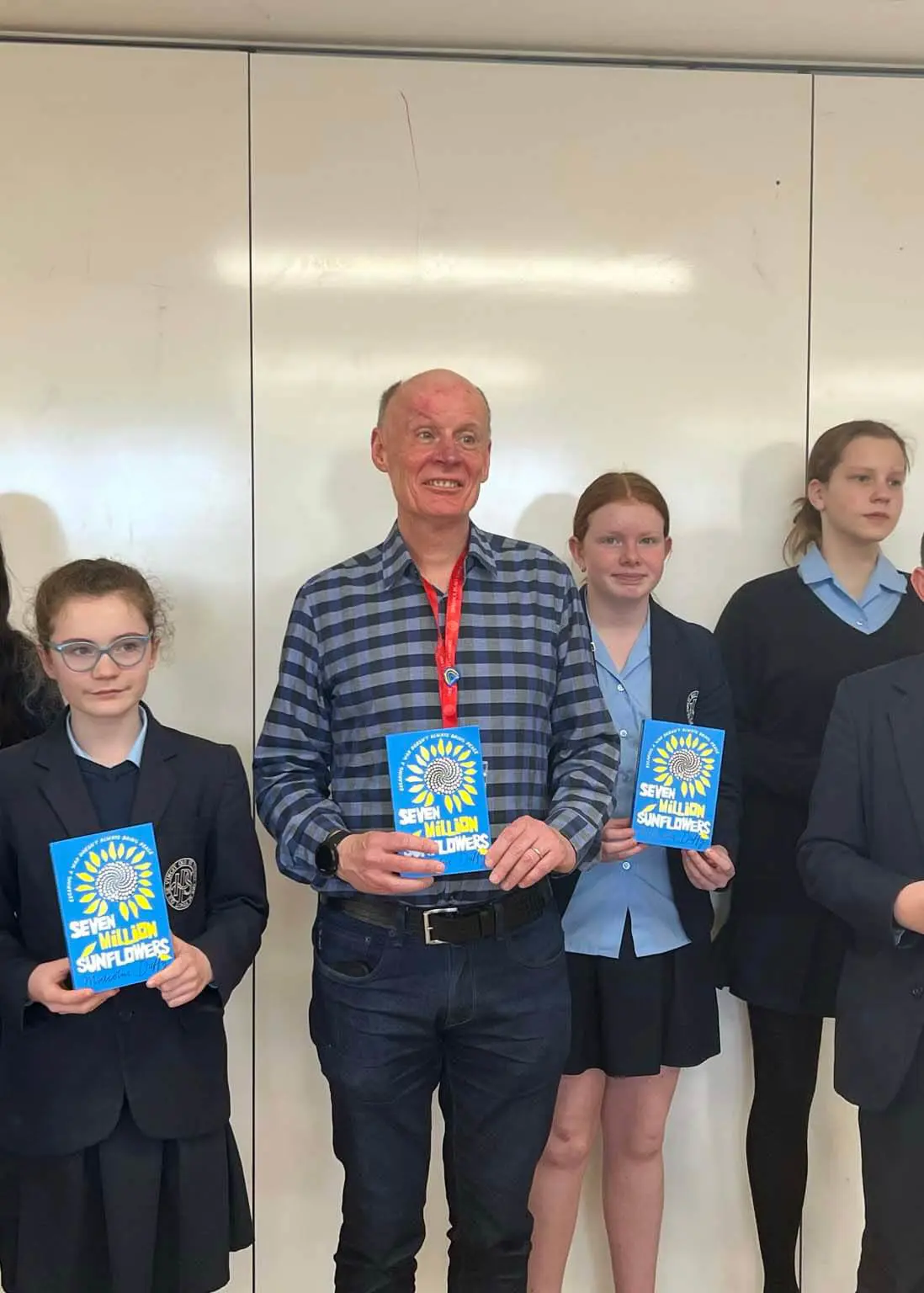 Pupils standing with Malcolm Duffy with his books in their hands.