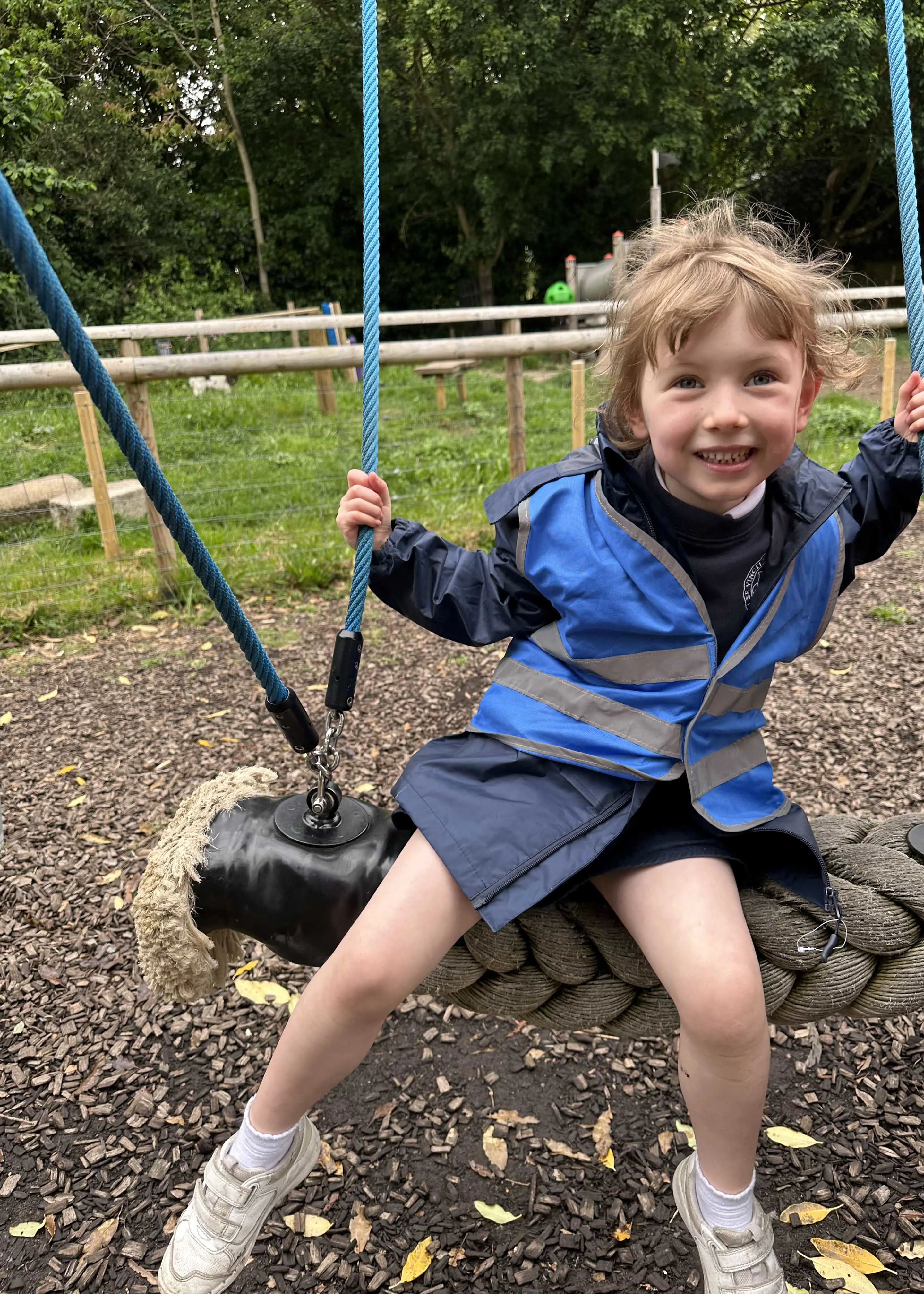 Kindergarten pupil on a swing at Battersea Park Zoo |  Ibstock Place School, a private school near Richmond, Barnes, Putney, Kingston, and Wandsworth on an overseas trip. 