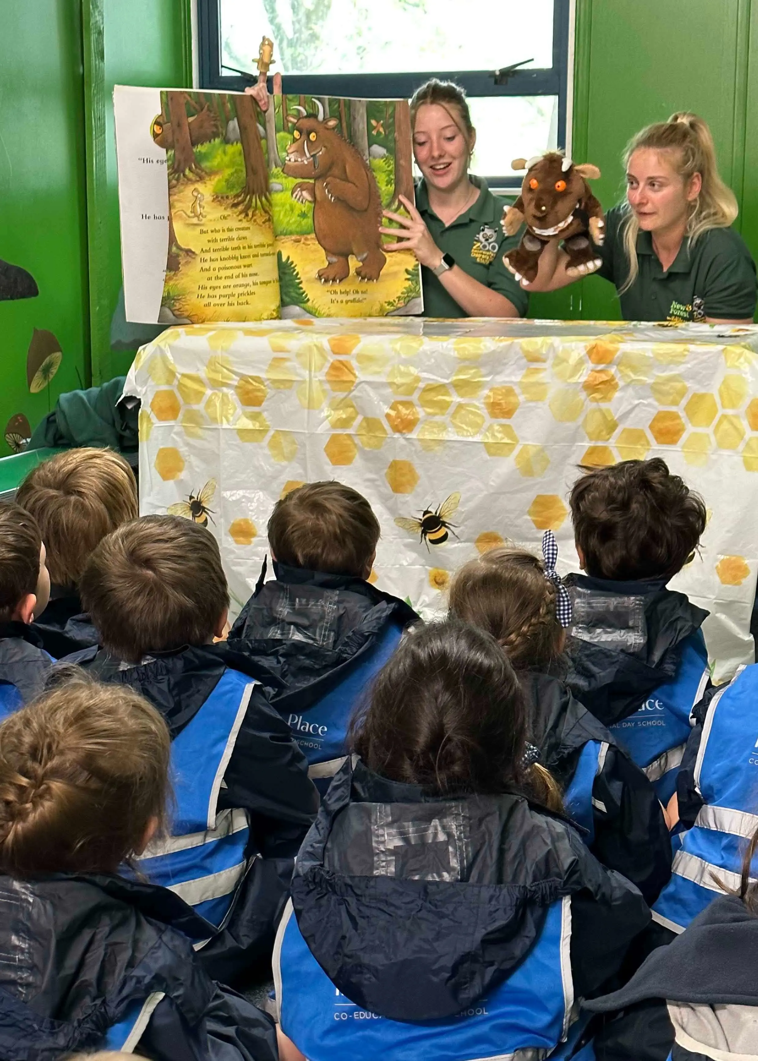 Kindergarten pupil having a story time at Battersea Park Zoo |  Ibstock Place School, a private school near Richmond, Barnes, Putney, Kingston, and Wandsworth on an overseas trip. 