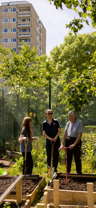 Senior pupils with a member of staff in the garden of Ibstock Place School learning gardening.