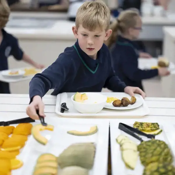 prep pupils serving himself a piece of fruit at Ibstock Place School, near Richmond.