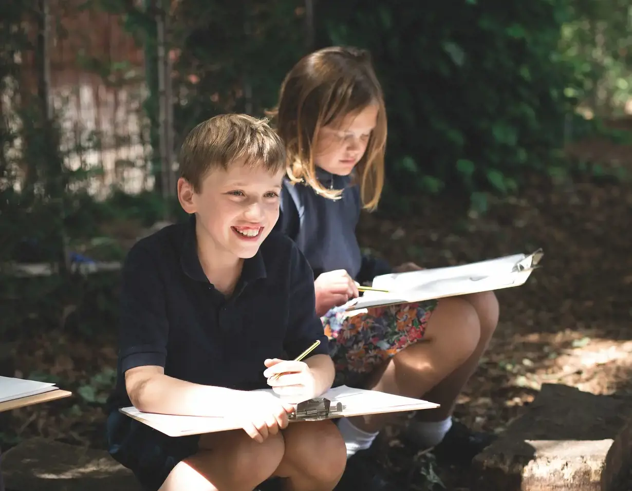 Prep pupils studying in the nature at the forest school of at Ibstock Place School, a private school near Richmond
