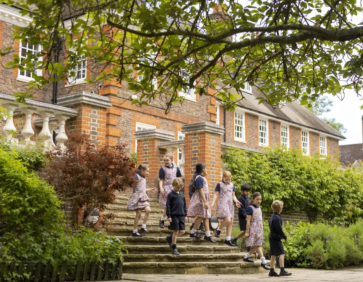 Prep pupils running down the main stairs of Ibstock Place School.
