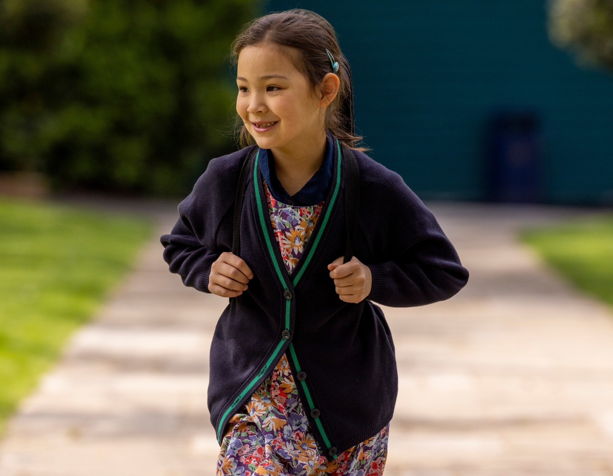 Prep pupil walking in the school with her backpack on her shoulders at Ibstock Place School