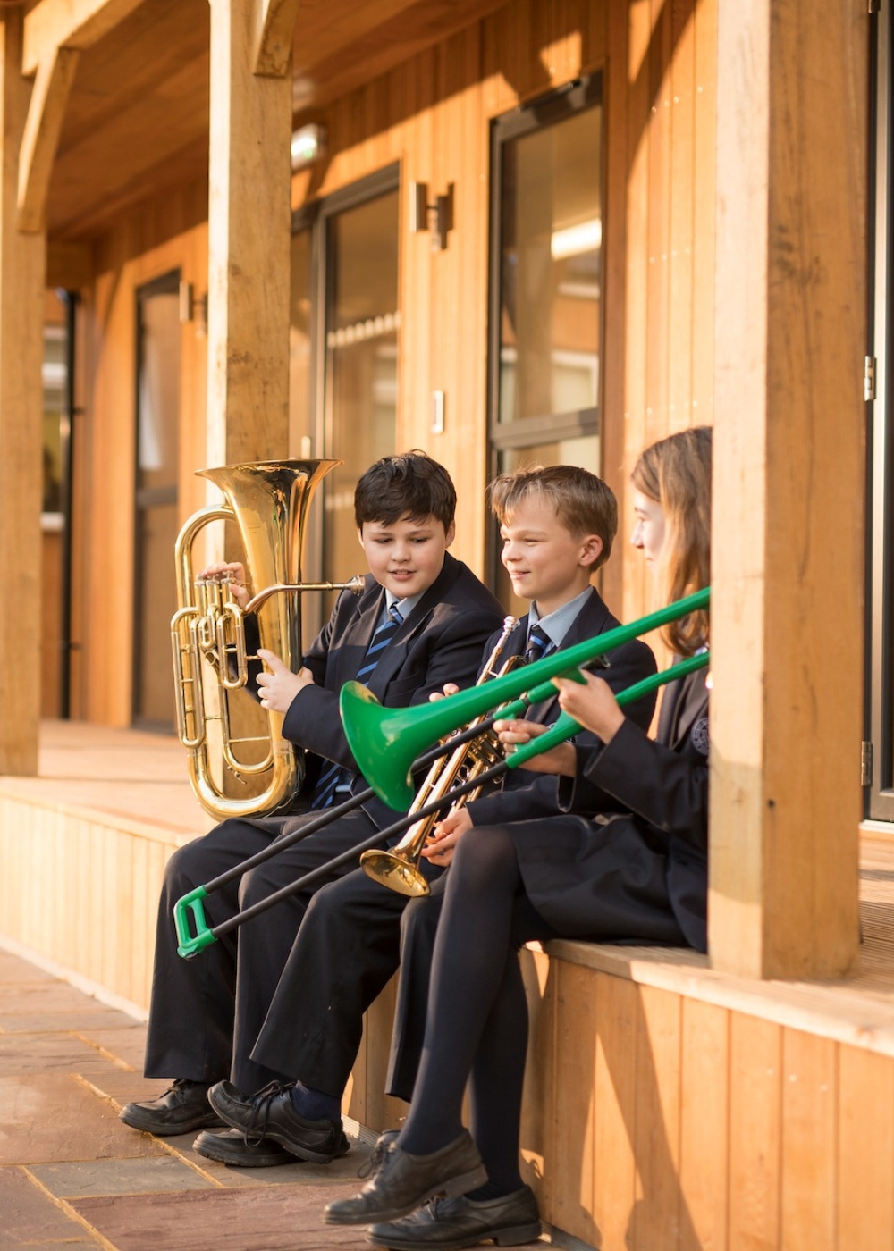 Senior pupils sitting with their musical instruments at Ibstock Place School, a private school near Richmond, Barnes, Putney, Kingston, and Wandsworth