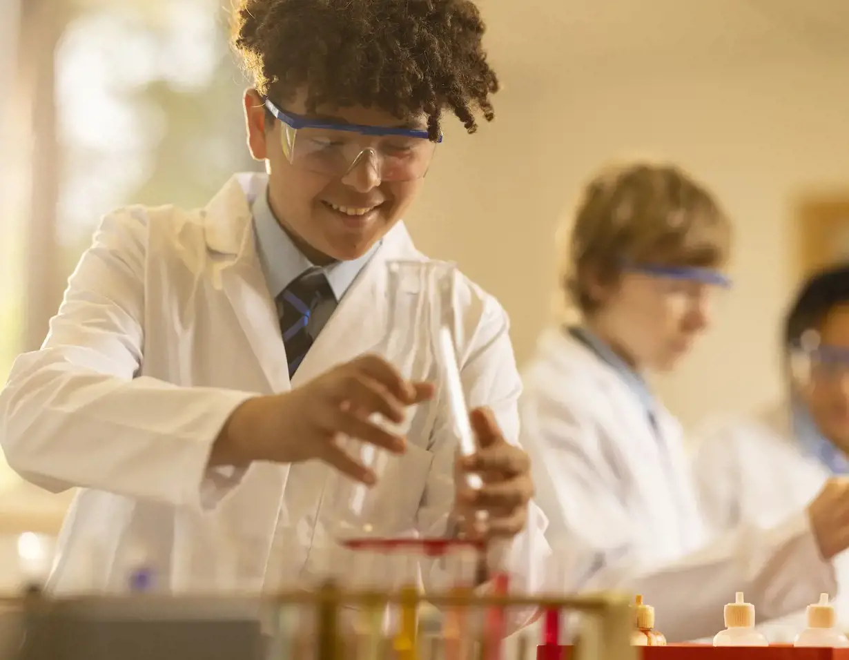 Senior pupil wearing lab safety gear in doing experiment at Ibstock Place School, a private school near Richmond.