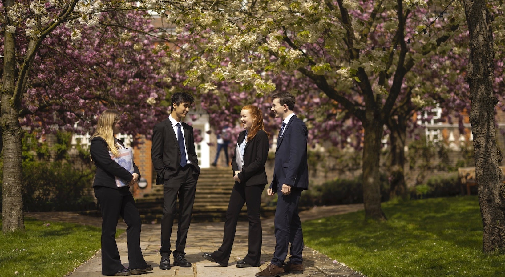 Sixth form pupils walking through the beautiful campus of  Ibstock Place School, a private school near Richmond, Barnes, Putney, Kingston, and Wandsworth.