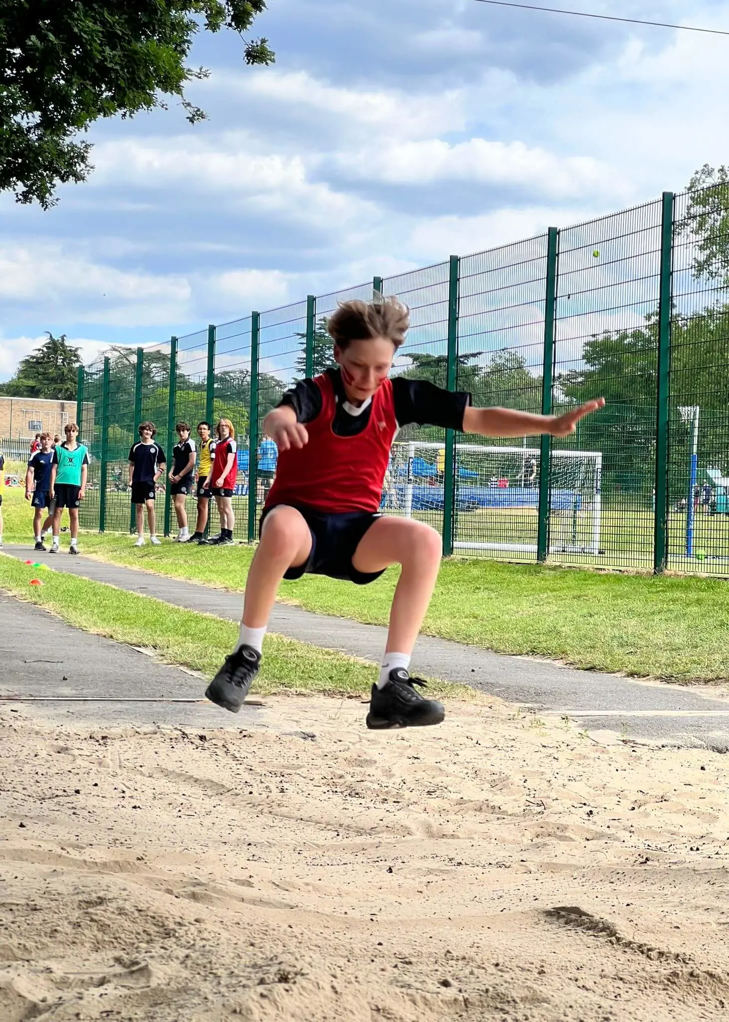 Track and Field Day, pupil doing a long jump | Ibstock Place School, Roehampton, Private School Near Richmond, Barnes, Putney, Kingston, & Wandsworth 