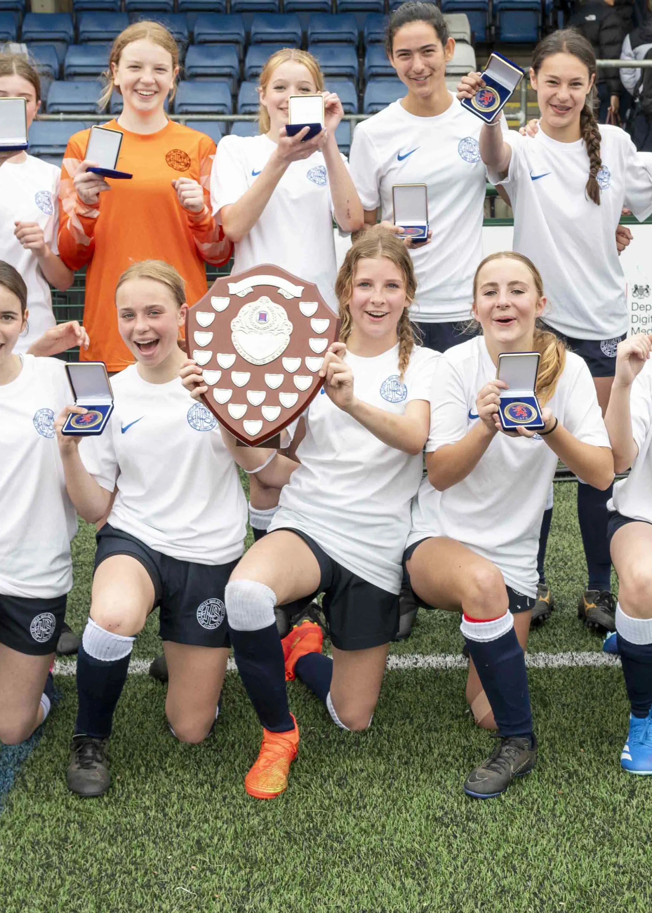 Team photo of U15 football girls team with trophy| Ibstock Place School, a private school near Richmond, Barnes, Putney, Kingston, and Wandsworth.