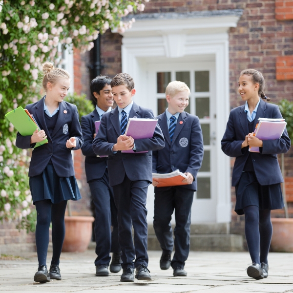 Senior pupils walking to their class with books in their hands.