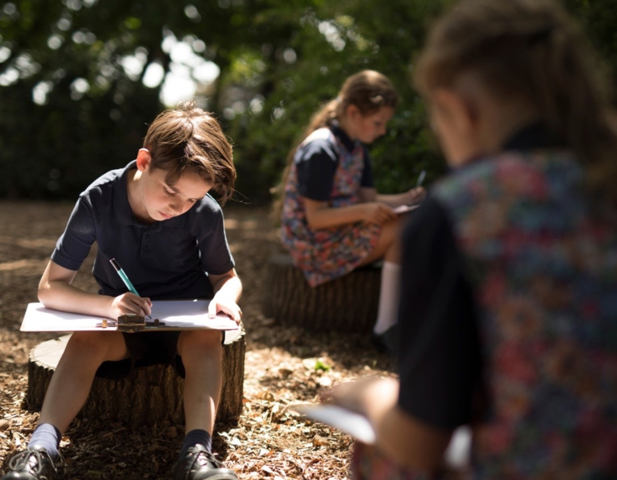 Prep pupils studying in the nature at the forest school of at Ibstock Place School, a private school near Richmond